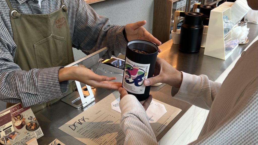 渋谷スクランブルスクエア店のカウンターでコーヒーを提案するバリスタ